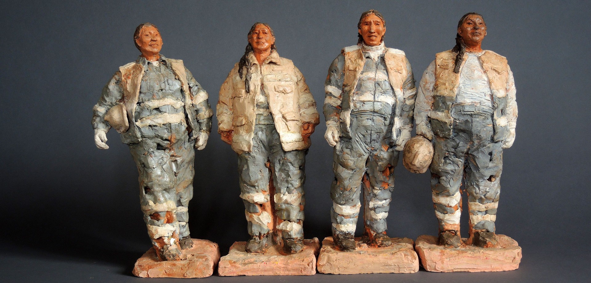 Skulpturen von 4 Bauarbeiterinnen in Arbeitskleidung.