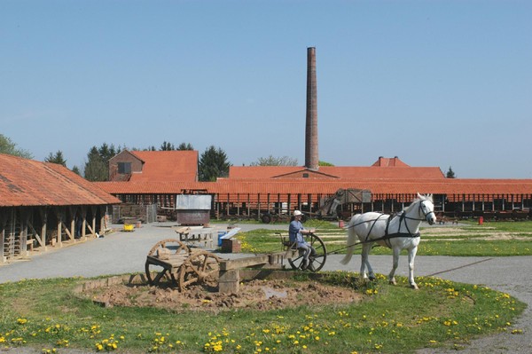 Ein Pferd mischt mit Hilfe des Pferdegöpels den Lehm auf.
