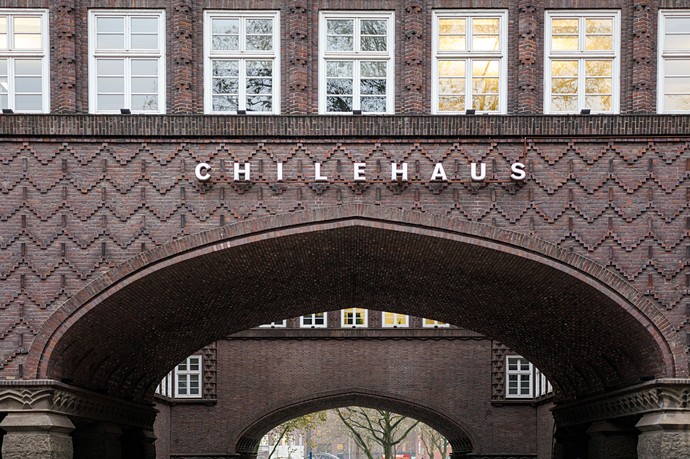 Blick auf die Backsteinfassade und einen leicht spitz zulaufende Rundbogendurchgang des Chilehauses
