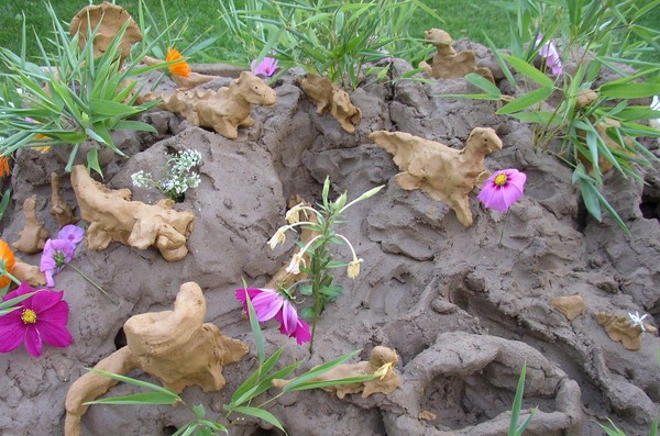 Eine Landschaft wird von kleinen Dinosauriern aus Lehm bevölkert.